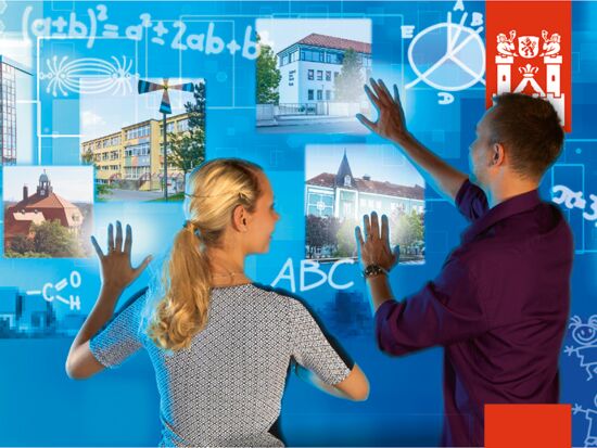 Imagebild der Kampagne Neue Stadt. Neues Glück zum Thema Bildung und Lernen. Zwei junge Erwachsene verschieben Bilder von Schulen auf einer virtuellen Tafel mit Buchstaben und mathematischen Formeln darauf.