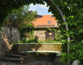 Sitzbank Lessing-Gedenkstätte, Mauer und Gedenktafel im Hintergrund. 
