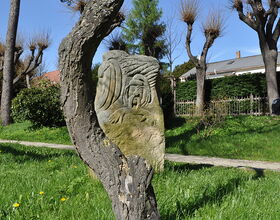 Baum und Skulptur an der Schillerpromenade. 