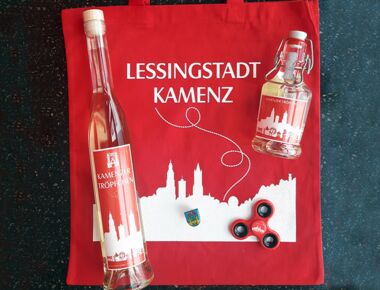 Beispielbild für Souvenirs der Lessingstadt Kamenz mit Kamenz-Beutel, zwei unterschiedlich großen Flaschen Kamenzer Tröpfchen Kräuterlikör, Kamenz-Finger-Spinner und Kamenz-Pin.