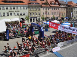 Sportler starten zum Wettkampf und werden von den Zusachauern angefeuert
