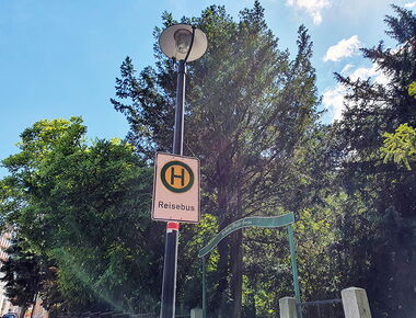 Haltestelle an der Poststraße neben dem Wilhelm Weiße Garten. Haltestellenschild mit Aufschrift Reisebus. Haltestellen-Beispiel für Reisebusse. Im Hintergrund Wilhelm-Weiße-Garten mit Schild.. 