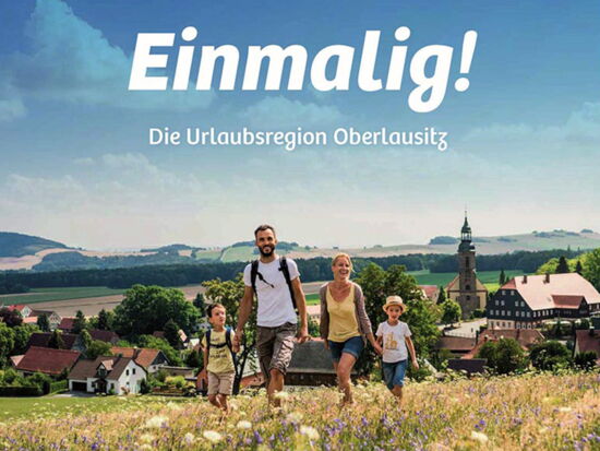 Titelbild der Imagebroschüre Oberlausitz mit der Aufschrift "Einmalig! Die Urlaubsregion Oberlausitz". Eine Familie mit zwei jüngernen Kindern beim Wanderausflug auf einer Wiese. Im Hintergrund Oberlausitzer Berge, Felder und ein Städtchen mit Kirche.