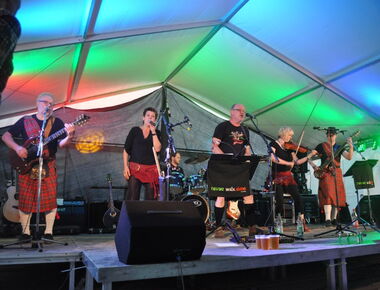 Bandauftritt zur Fête de la Musique am 21. Juni in Kamenz. Eine Band mit fünf Mitgliedern steht auf der Bühne und gibt ein Konzert. Sie spielen Gitarre, Geige, Keyboard und singen gemeinsam auf der beleuchteten Bühne.. 