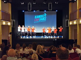 Auftritt der Tanztheatergruppe Kamenz can Dance als Beispiel für Veranstaltungen im Stadttheater Kamenz. Eine Gruppe Kinder tanz gemeinsam im Hip Hop Stil auf der Bühne. Publikum schaut zu. Im Hintergrund eine digitale Leinwand mit Logo der Gruppe.. 