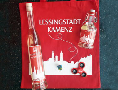 Beispielbild für Souvenirs der Lessingstadt Kamenz mit Kamenz-Beutel, zwei unterschiedlich großen Flaschen Kamenzer Tröpfchen Kräuterlikör, Kamenz-Finger-Spinner und Kamenz-Pin.. 