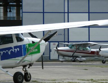 Hanger mit Flugzeugen auf dem Kamenzer Flugplatz. Links im Vordergrund ist seitig ein Segelflugzeug mit dem Logo MDR Radio Sachsen zu sehen. Rechts im Hintergrund weitere Flugzeuge. Beispielbild für Freizeiteinrichtungen in Kamenz.