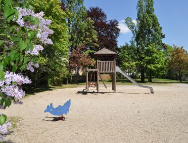 Spielplatzanlage auf dem Kamenzer Lessingplatz mit Holzklettergerüst, Rutsche und Delfin-Federwippe. Als Beispiel eines Spielplatzes in Kamenz.